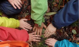 Kinderhände greifen im Kreis auf den Boden | © Caritas München und Oberbayern
